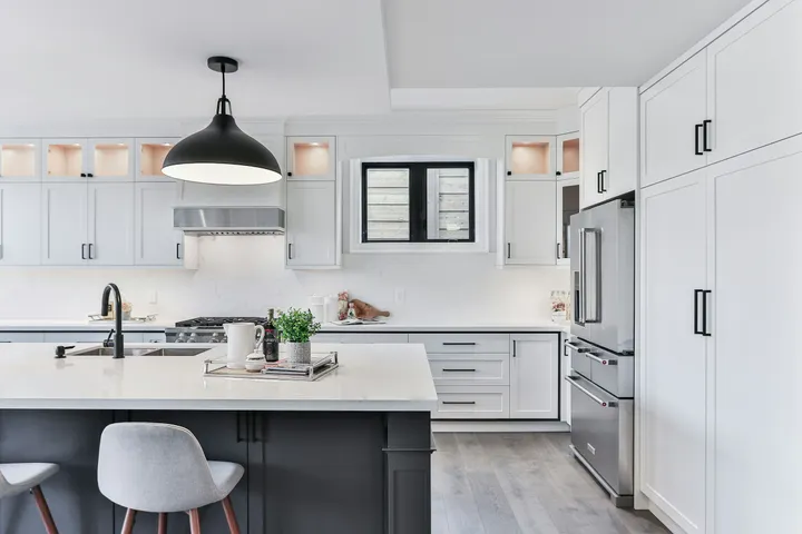 Modern kitchen remodel with white cabinetry and marble countertops